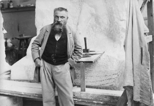 Auguste-Rodin posando al lado de su escultura